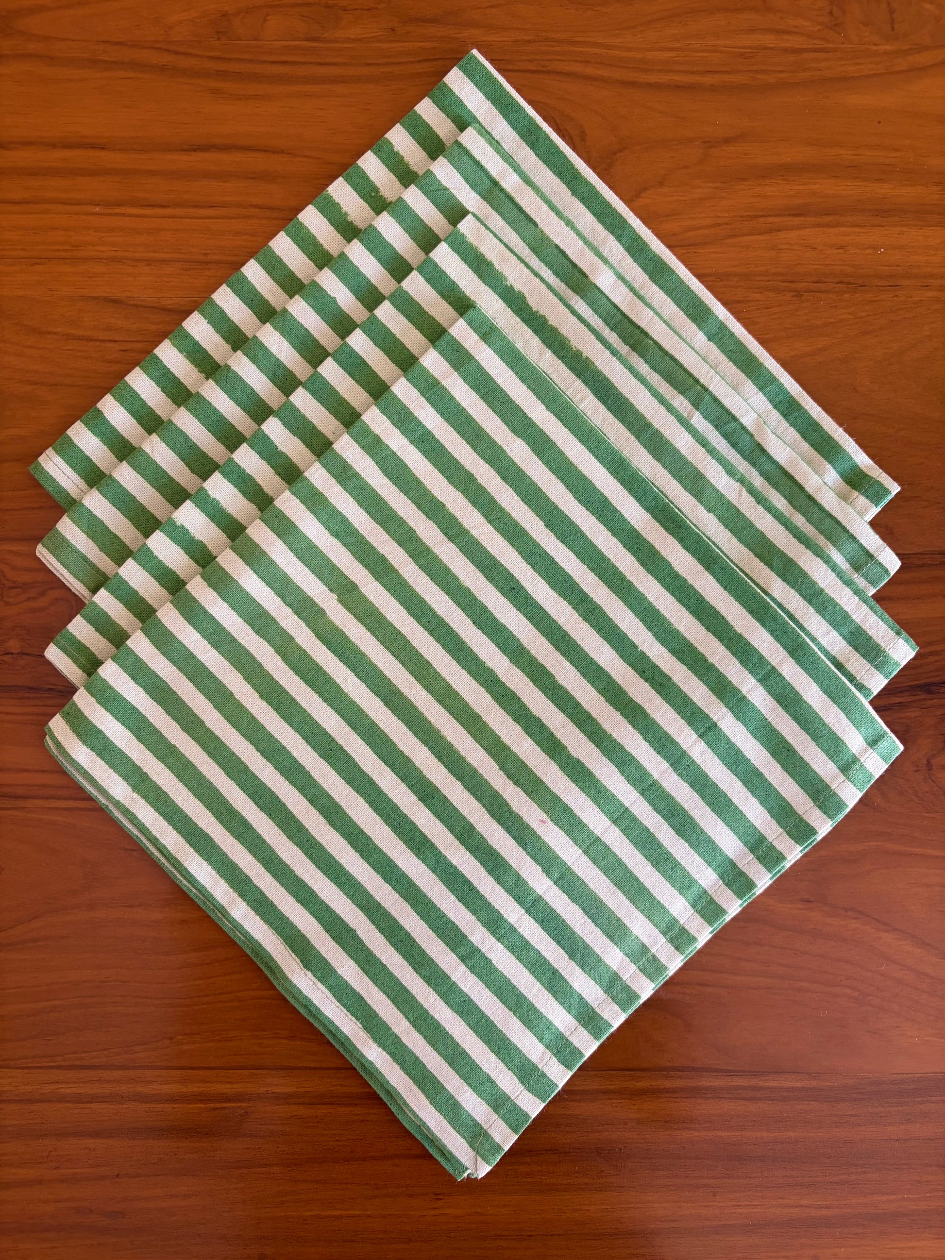 House of Mulmul - Blockprinted Cotton Table Napkins. Green and white striped table napkins on a wooden surface