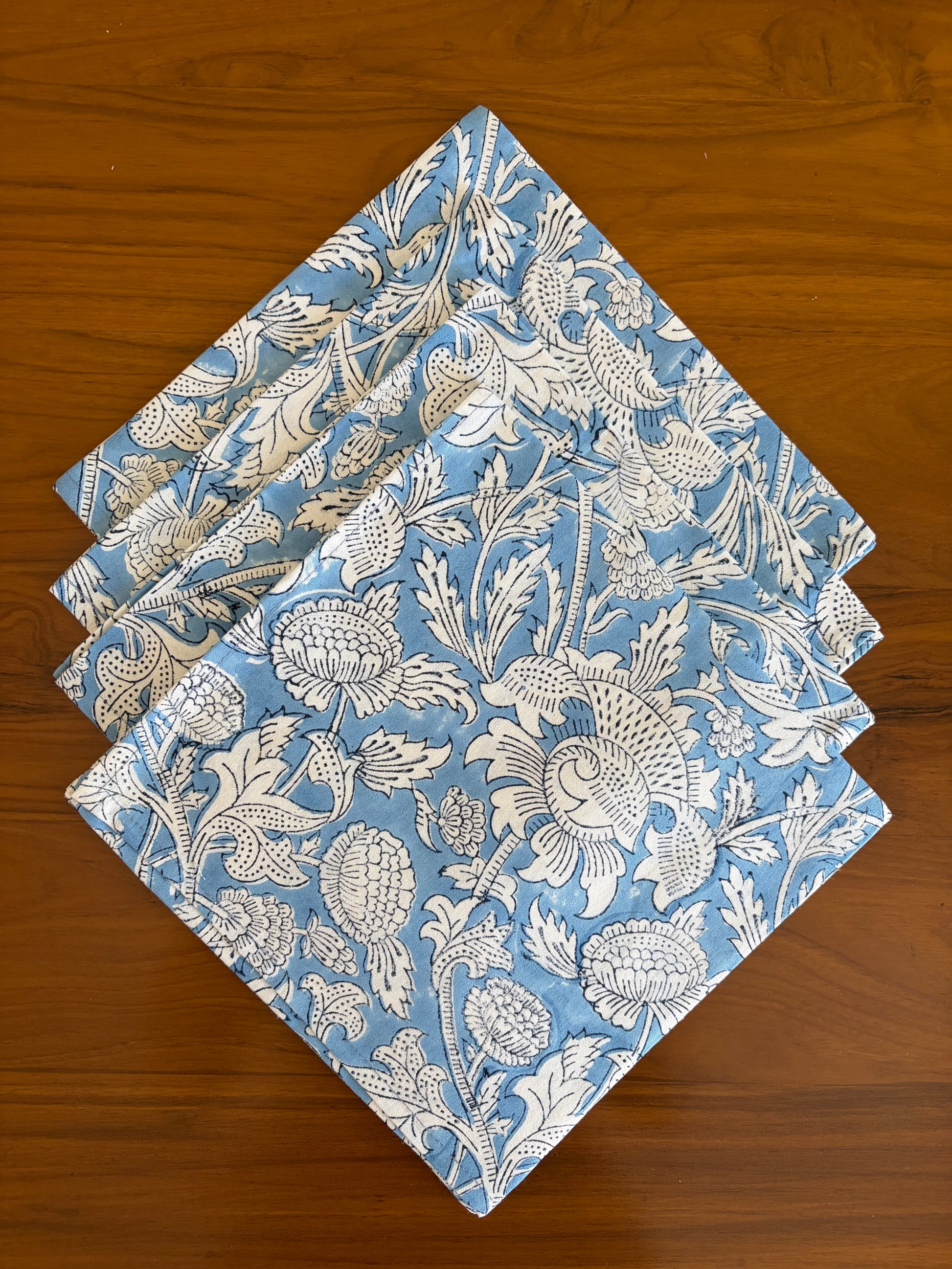 House of Mulmul - Blockprinted Cotton Table Napkins. Set of blue and white patterned napkins on a wooden surface