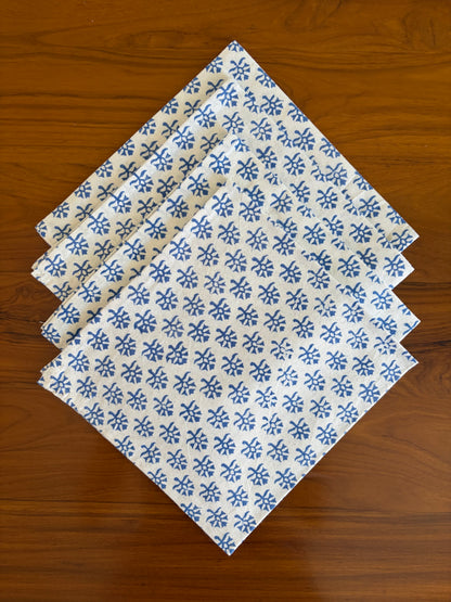 House of Mulmul - Blockprinted Cotton Table Napkins. Set of four folded fabric napkins with blue floral pattern on a wooden surface