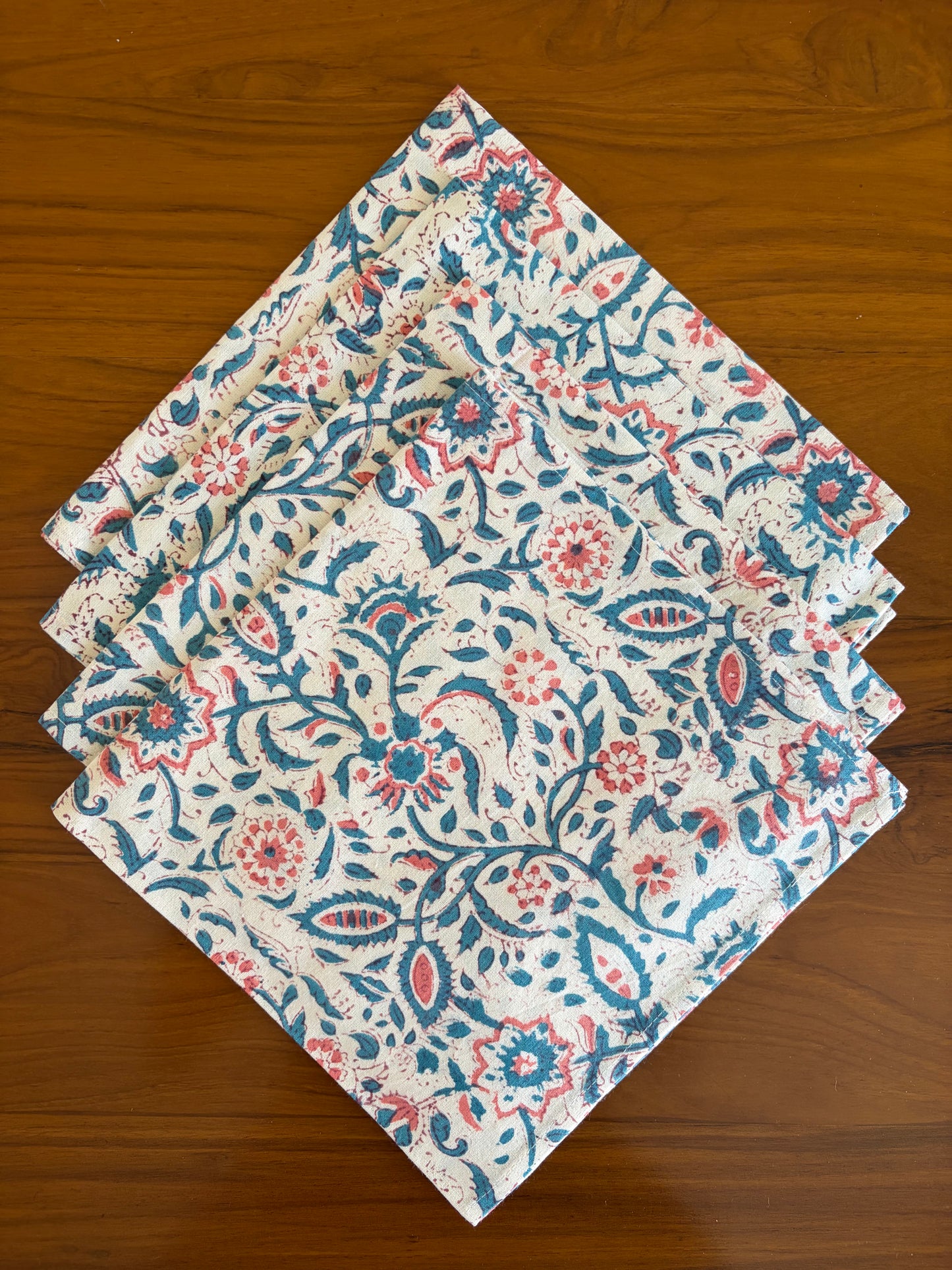 House of Mulmul - Blockprinted Cotton Table Napkins. Set of floral patterned in paisley pattern in blue and red napkins on a wooden surface