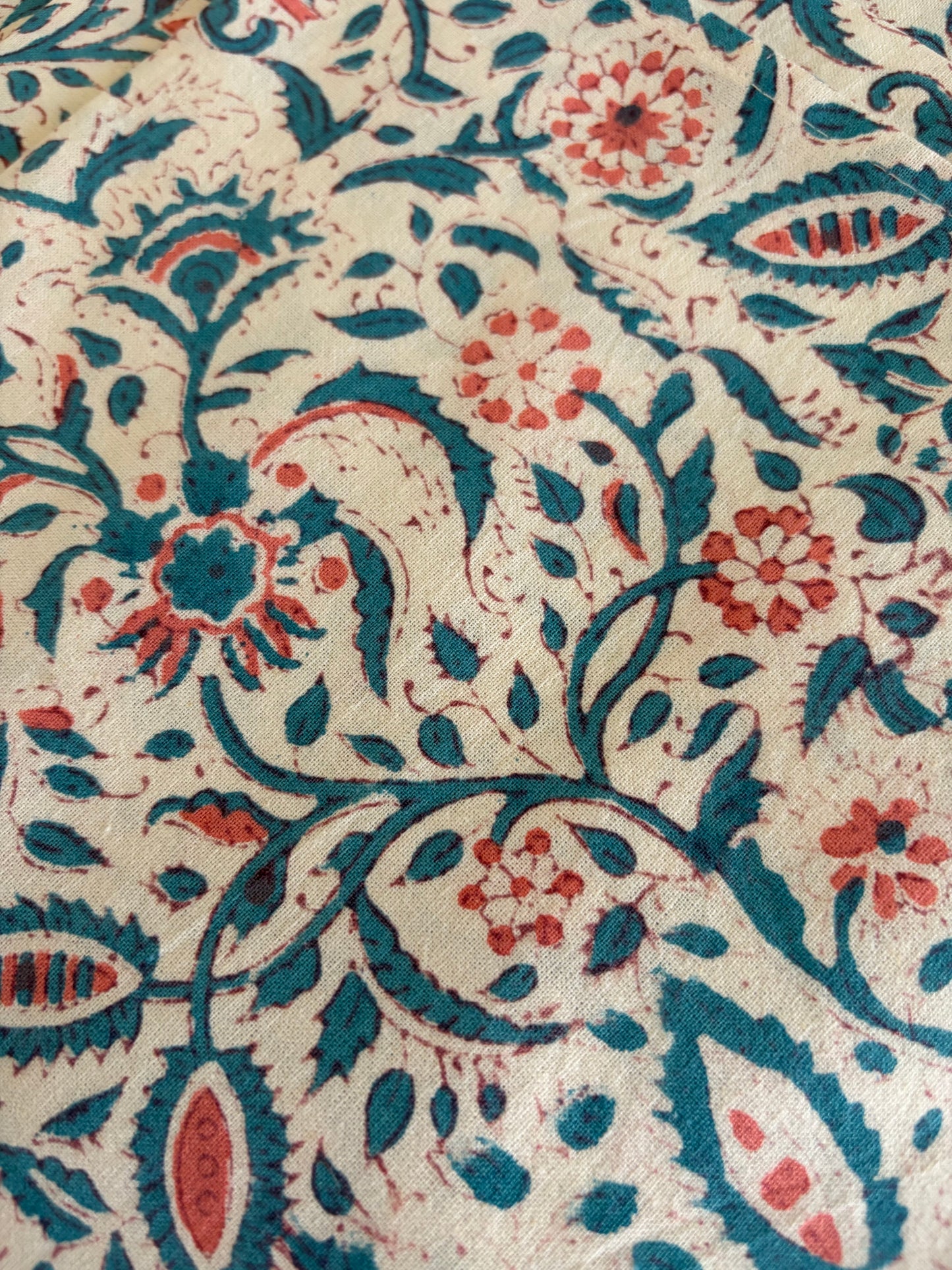 House of Mulmul - Blockprinted Cotton Table Napkins. Close-up of a fabric with intricate paisley pattern in blue and red on a beige background