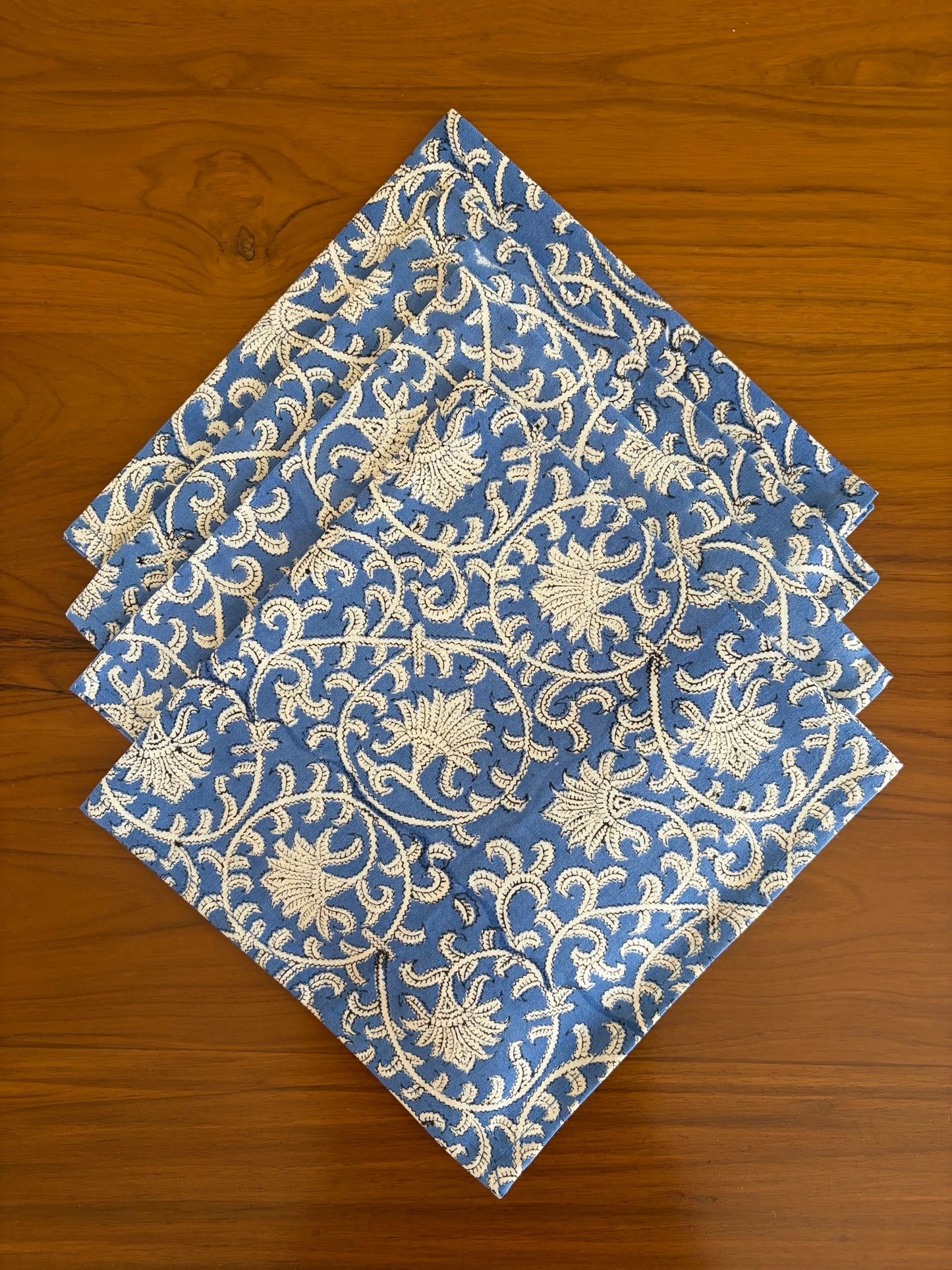 House of Mulmul - Blockprinted Cotton Table Napkins. Set of blue and white patterned cotton napkins on a wooden surface