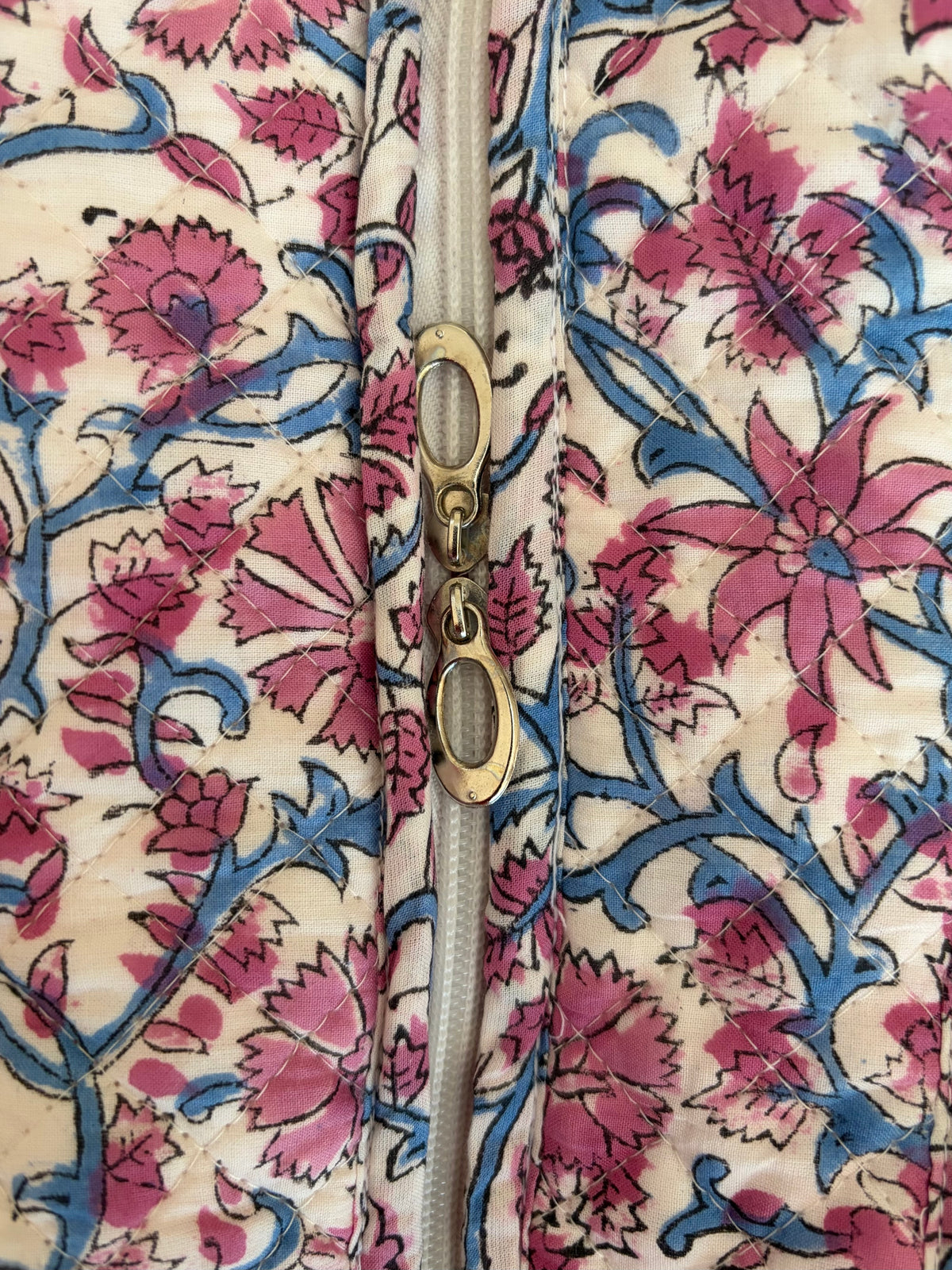 House of Mulmul - Blockprinted Cotton Tote Bag, Travel Bag. Close-up of a quilted tote bag with a pink and blue floral block-print pattern on a cream background, featuring a metal zipper.