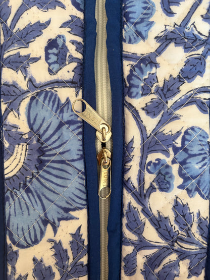 House of Mulmul - Blockprinted Cotton Tote Bag, Travel Bag. Close-up of a quilted fabric tote bag featuring a blue floral pattern on a cream background, with a central gold zipper.