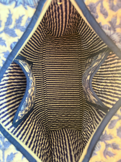 House of Mulmul - Blockprinted Cotton Tote Bag, Travel Bag. Close-up view from inside a striped tote bag, showing navy and beige horizontal stripes with blue trim and a blue floral patterned exterior visible at the edges.