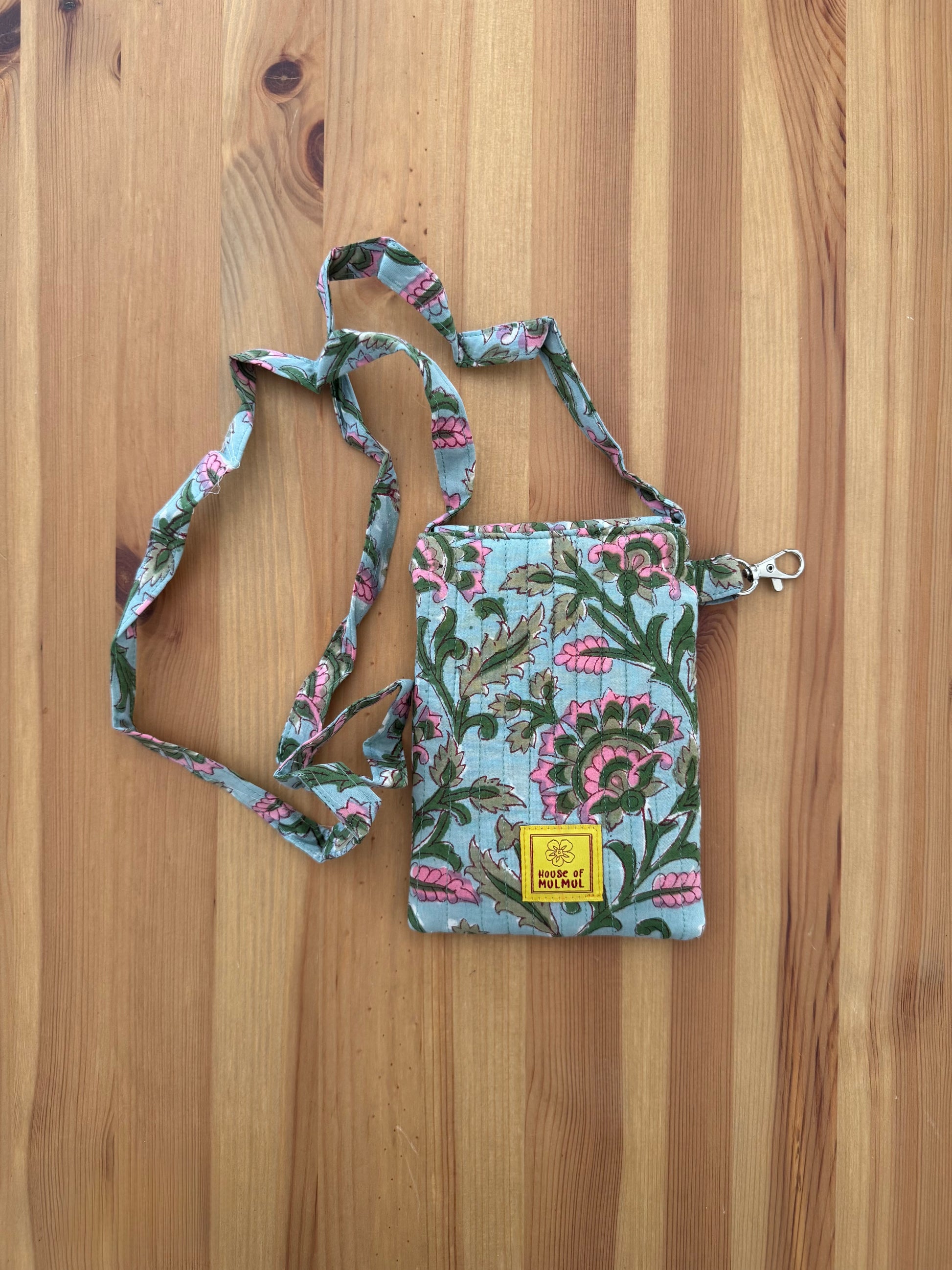 House of Mulmul - Blockprinted Crossbody Mobile Sling Bag. Floral patterned crossbody bag on a wooden surface