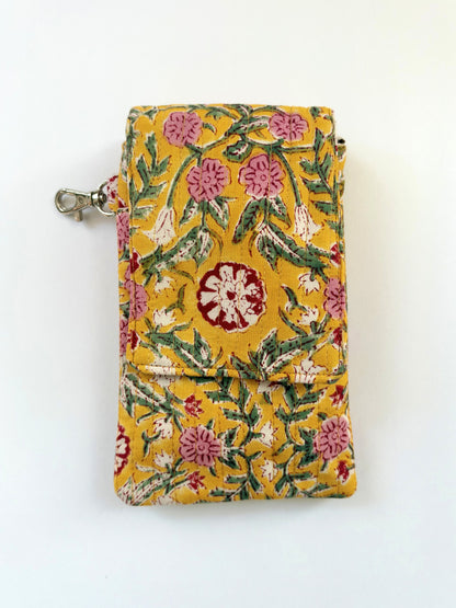 House of Mulmul - Blockprinted Mobile Sling Bag. A yellow fabric pouch with a floral pattern in pink, green, and red, featuring a silver metal clasp on the left side, shown against a plain white background.