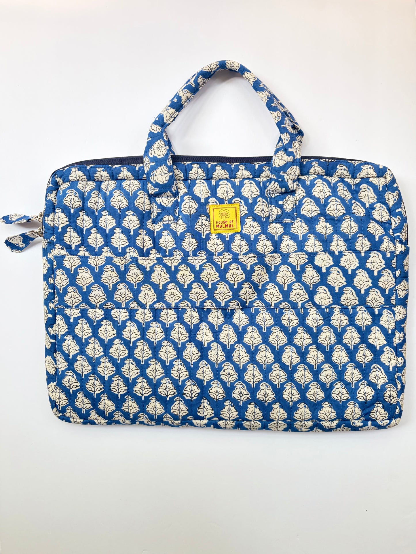 House of Mulmul - Blockprinted Cotton Quilted Laptop Bag. A quilted laptop sleeve featuring a blue and off-white block print pattern, with a small yellow brand label on the front.