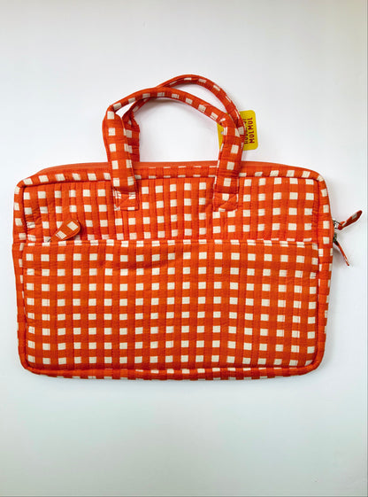 House of Mulmul - Blockprinted Cotton Quilted Laptop Bag. An orange and white gingham patterned laptop sleeve with dual top handles and a small yellow tag, photographed against a plain white background.