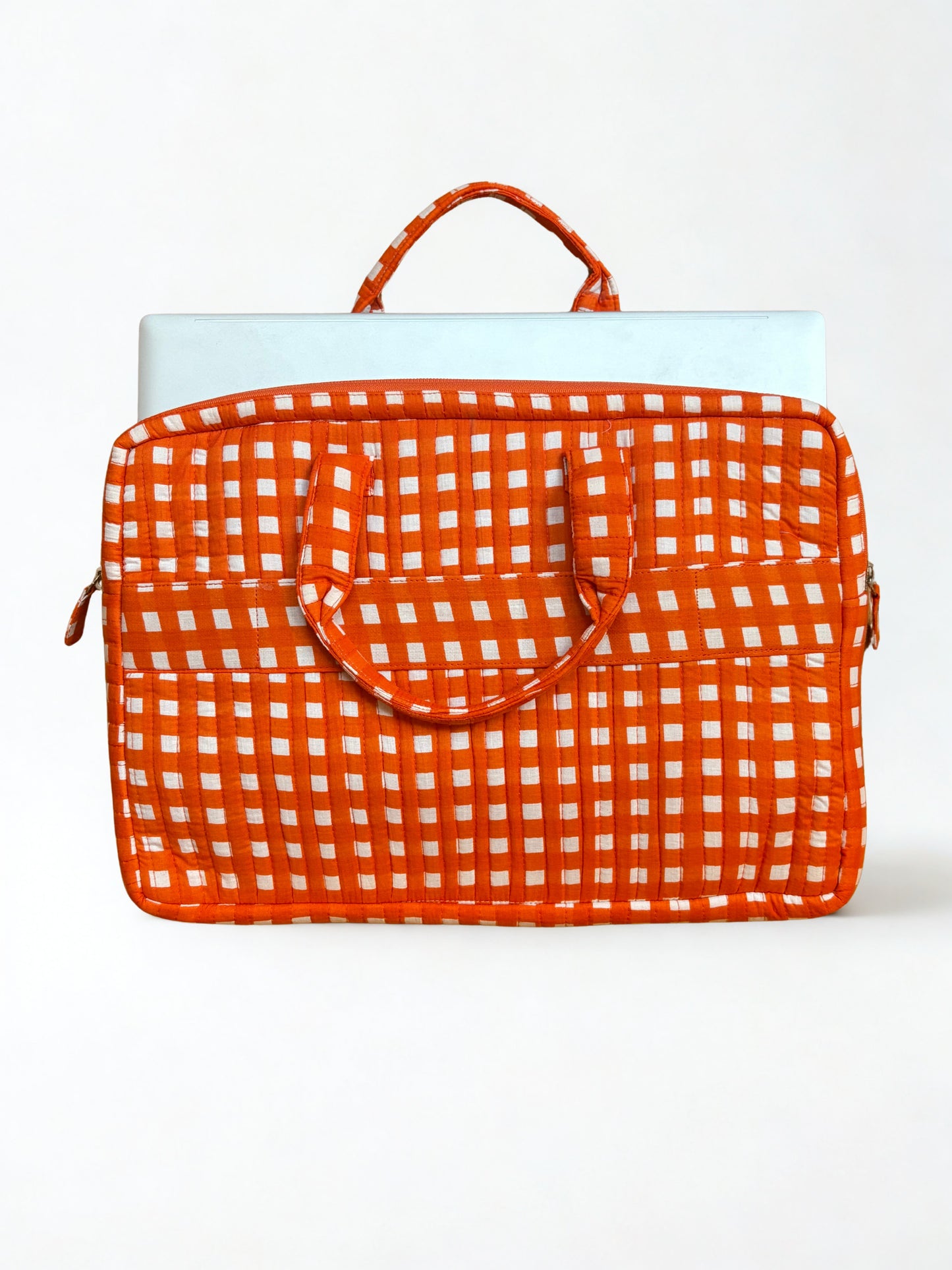 House of Mulmul - Blockprinted Cotton Quilted Laptop Bag. An orange and white checkered laptop sleeve with top handles, shown on a clean white background with a light blue laptop partially visible inside.