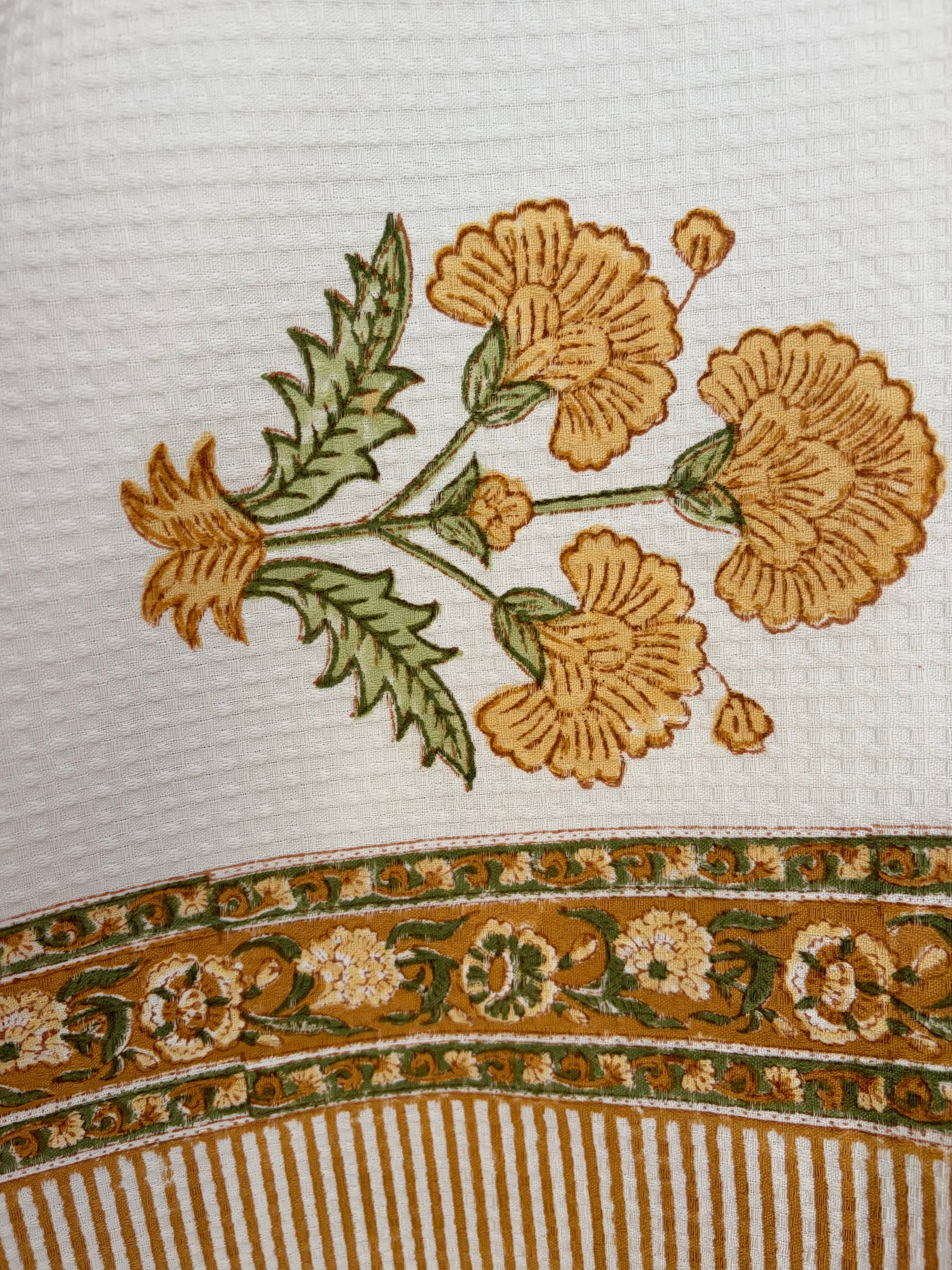 House of Mulmul - Cotton Bath Towel. Close-up of floral design on towel with a striped border.