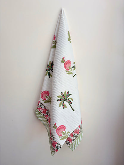 House of Mulmul - Cotton Bath and Hand Towel set. Floral patterned towel hanging on a white wall