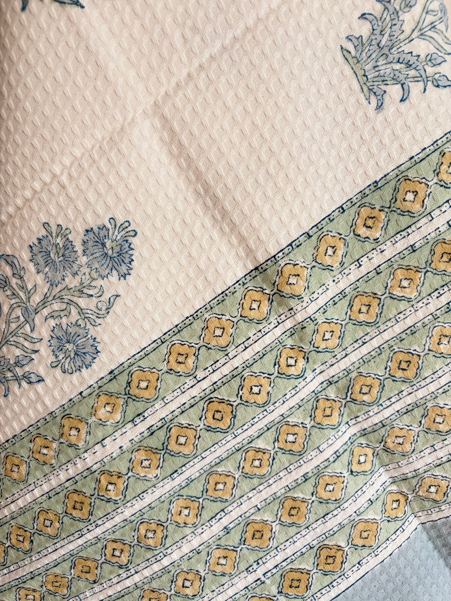 House of Mulmul - Cotton Bath Towel. Close-up of a towel with floral and geometric patterns on a white background