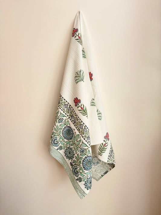 House of Mulmul - Cotton Bath Towel. Floral patterned towel hanging on a beige wall