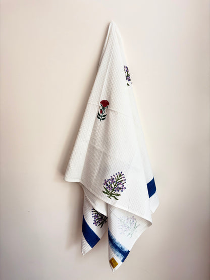 House of Mulmul - Cotton Bath Towel. White towel with embroidered floral designs on a beige background