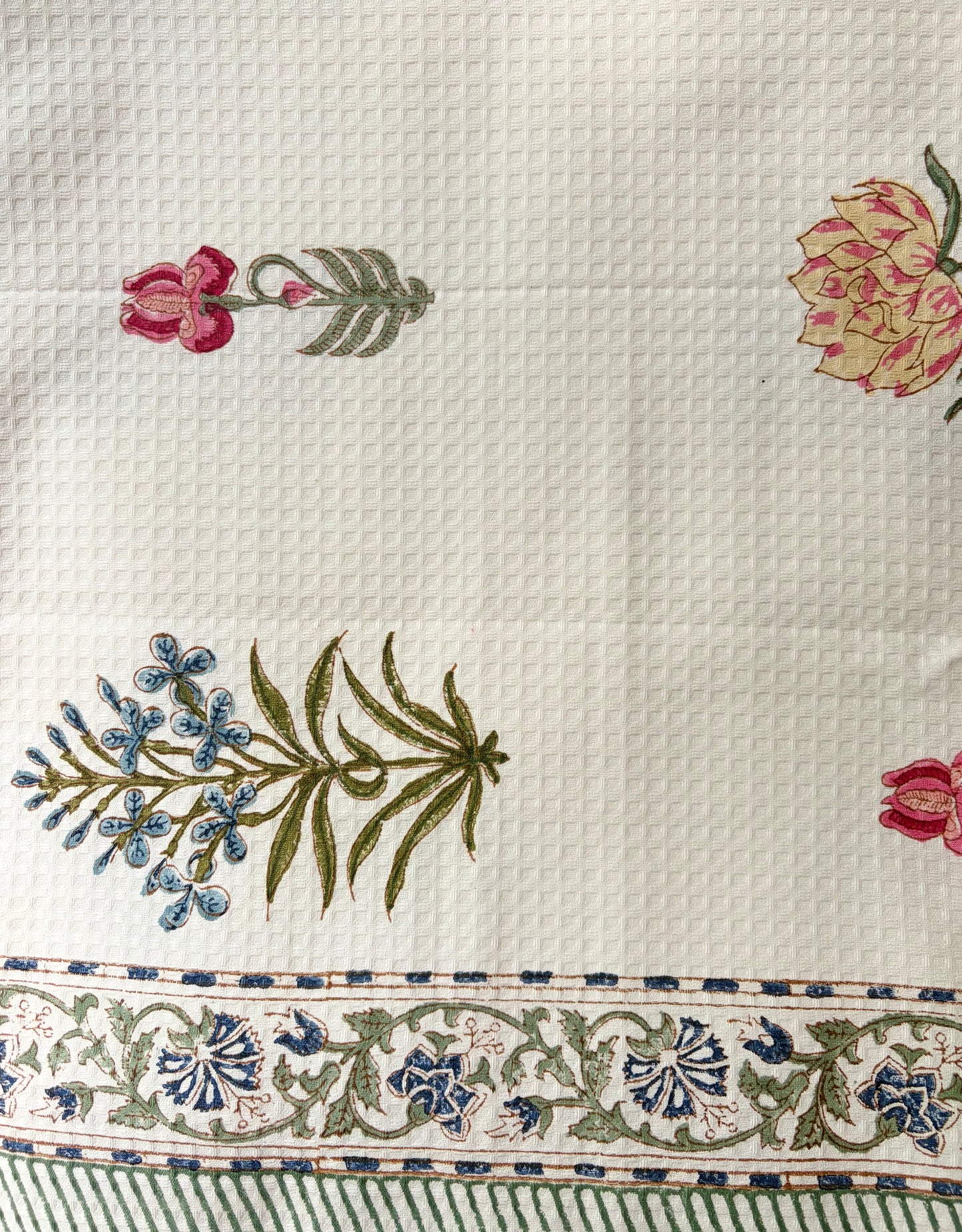House of Mulmul - Cotton Bath Towel. Close-up of embroidered towel with floral and leaf patterns on a white background