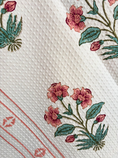 House of Mulmul - Cotton Bath Towel. Close-up of a cotton towel with floral patterns and red lines on a white background
