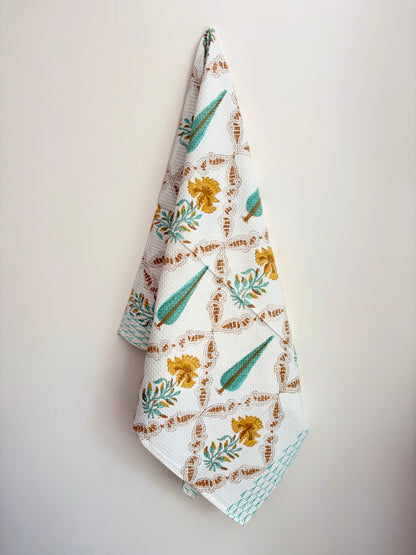 House of Mulmul - Cotton Bath Towel. Floral patterned towel hanging against a plain background