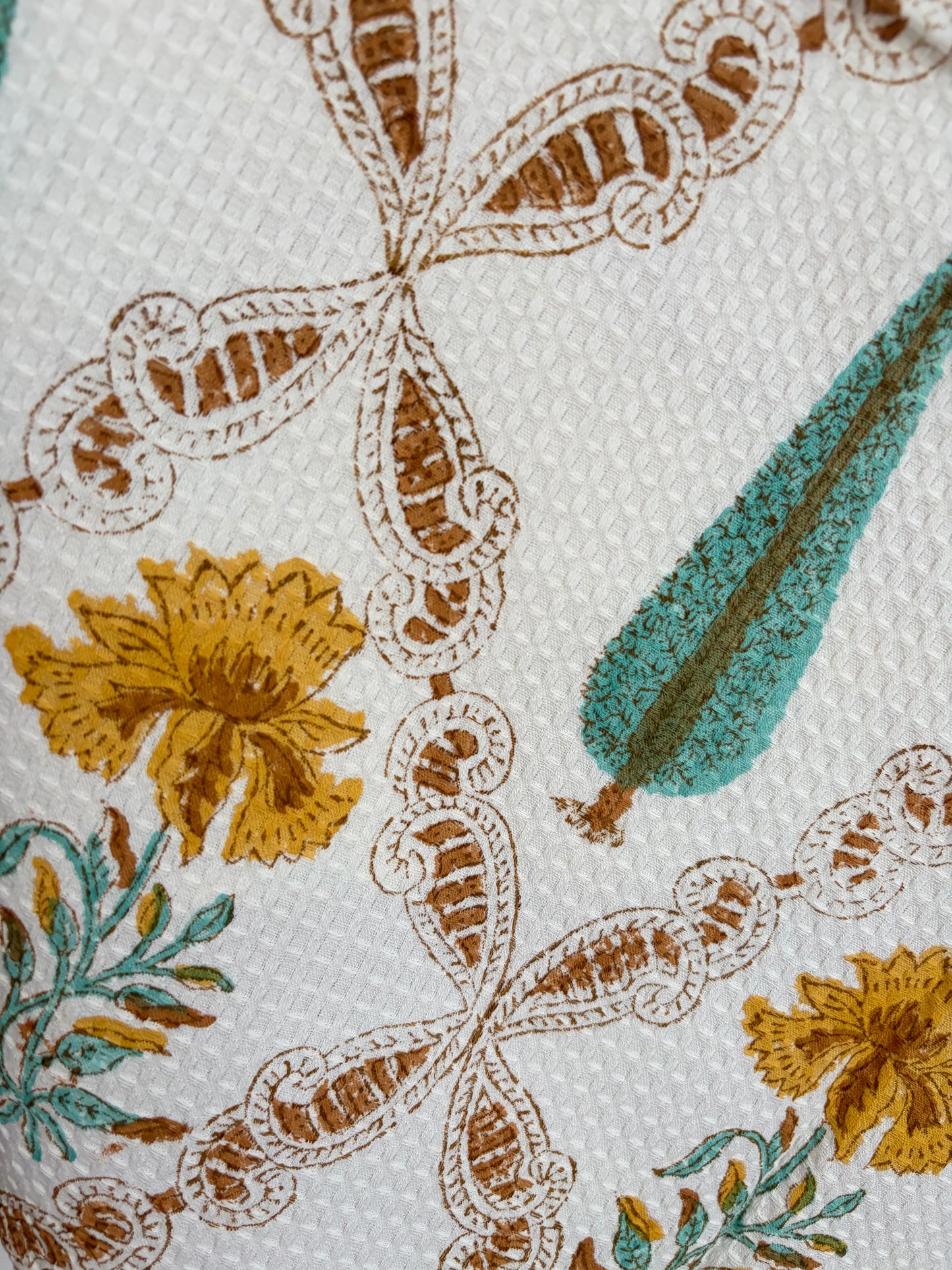 House of Mulmul - Cotton Bath Towel. Close-up of a floral pattern towel with leaves and flowers on a white background