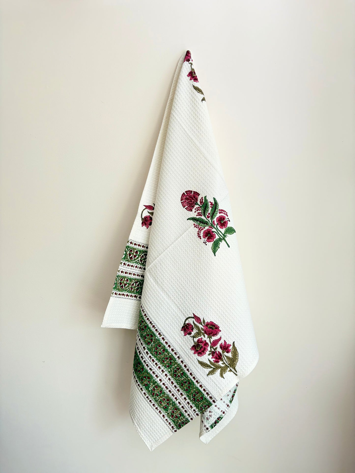 House of Mulmul - Cotton Bath Towel. Decorative towel with floral and geometric patterns on a plain background