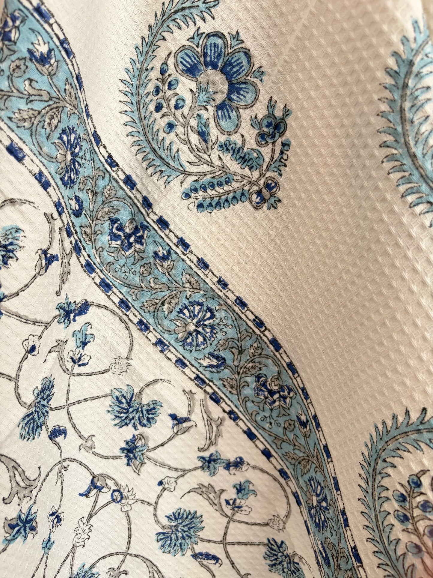 House of Mulmul - Cotton Bath Towel. Close-up of a decorative cotton towel with blue floral patterns on a white fabric