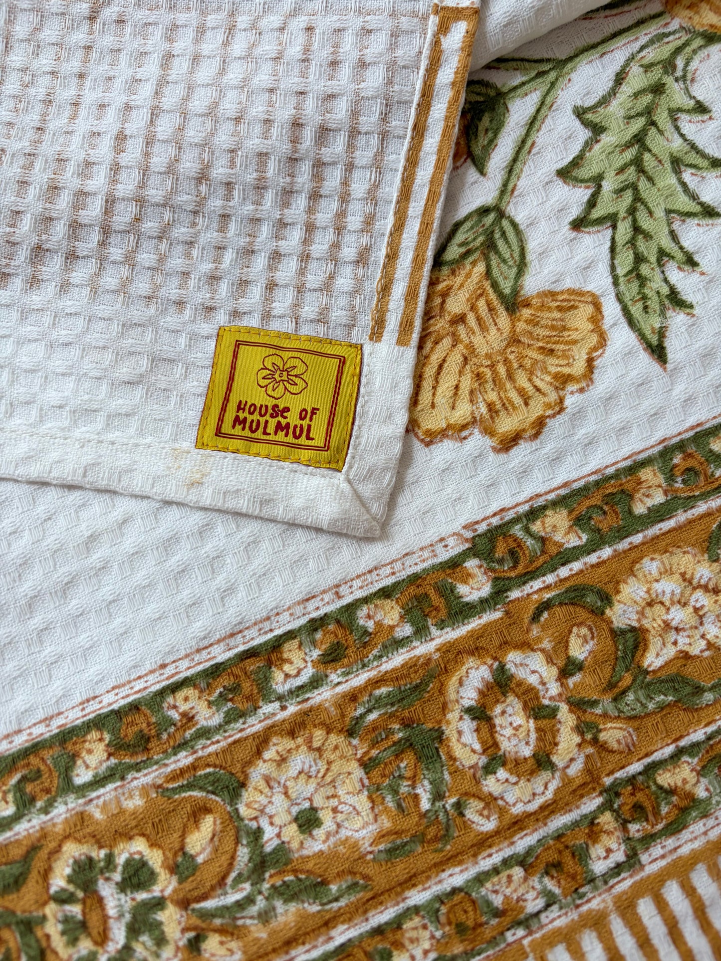 House of Mulmul - Cotton Bath Towel. Decorative towel with intricate patterns and a 'House of Mulmul' label.