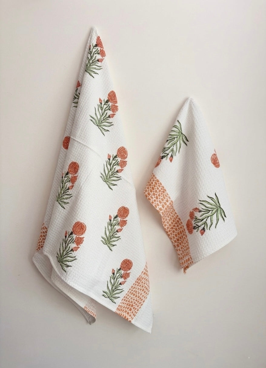 House of Mulmul - Cotton Bath and Hand Towel set. Two white towels with floral patterns on a light gray background