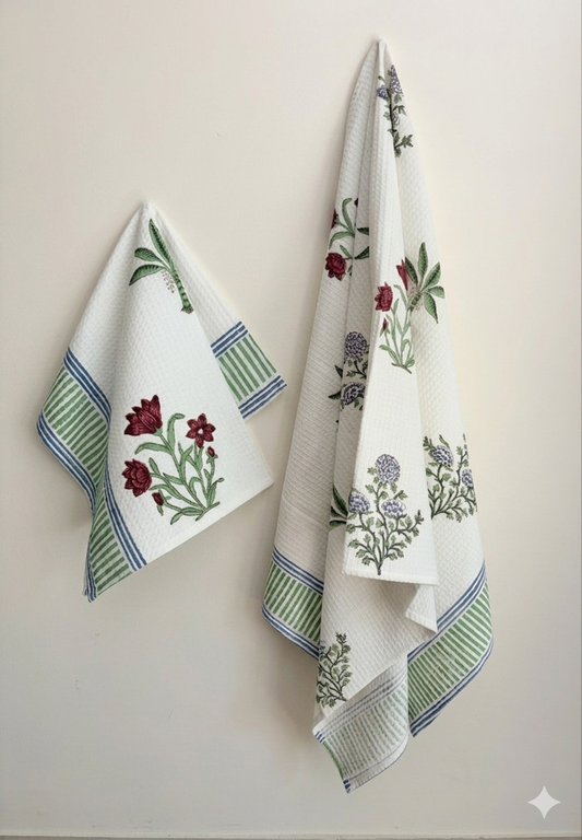 House of Mulmul - Cotton Bath and Hand Towel set. Two floral-patterned towels hanging against a plain background