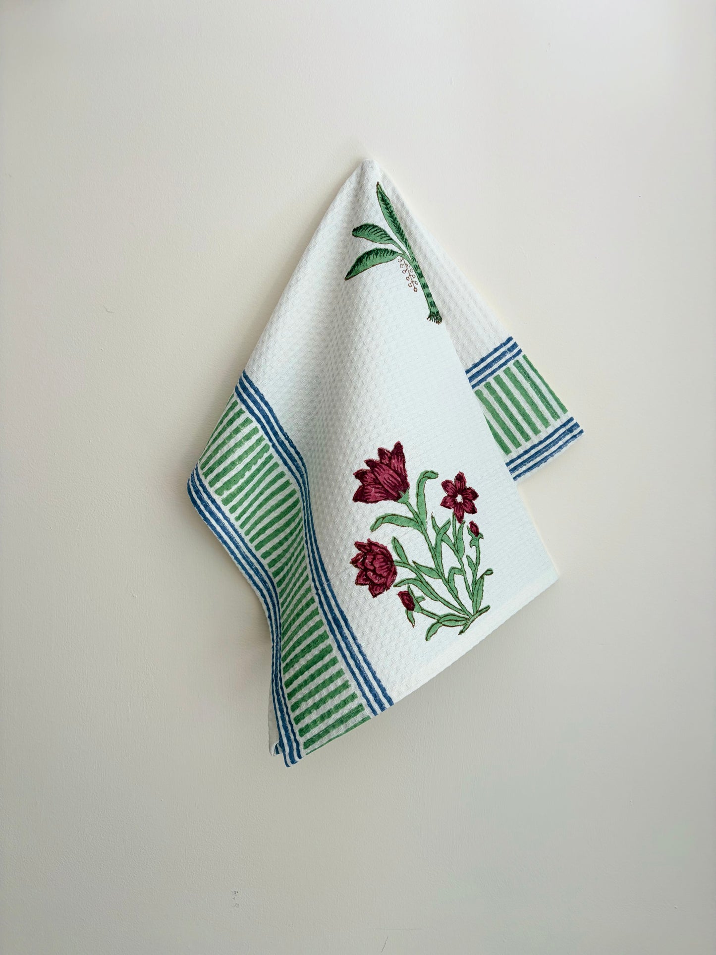 House of Mulmul - Cotton Bath and Hand Towel set. White towel with floral design and green and blue stripes on a plain background