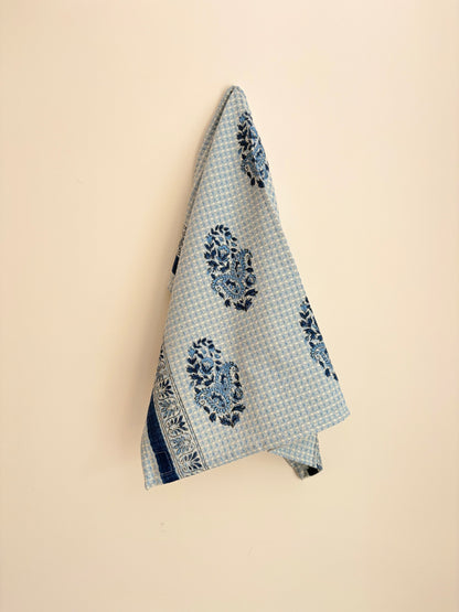 House of Mulmul - Cotton Hand Towel. Blue patterned towel hanging on a beige wall