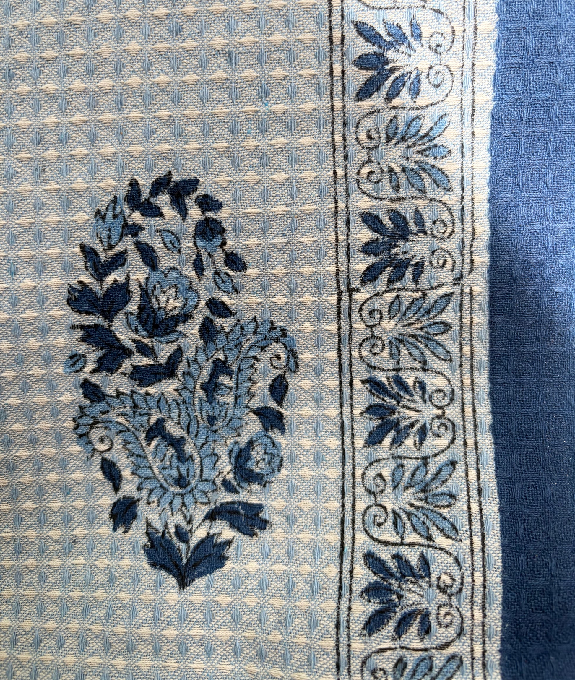 House of Mulmul - Cotton Hand Towel. Close-up of a blue and white patterned cotton towel with floral designs.