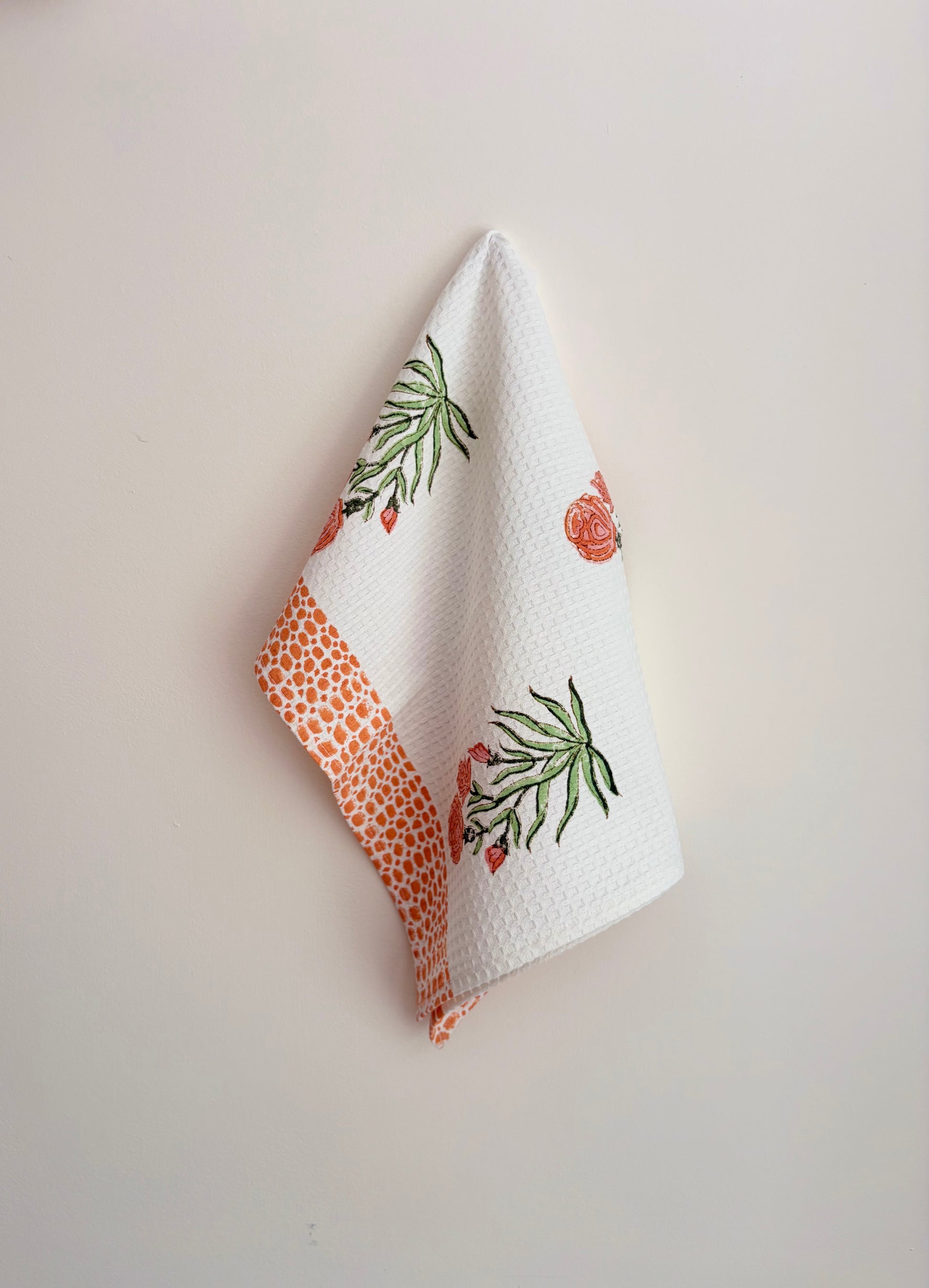House of Mulmul - Cotton Bath and Hand Towel set. White towel with floral patterns on a light gray background