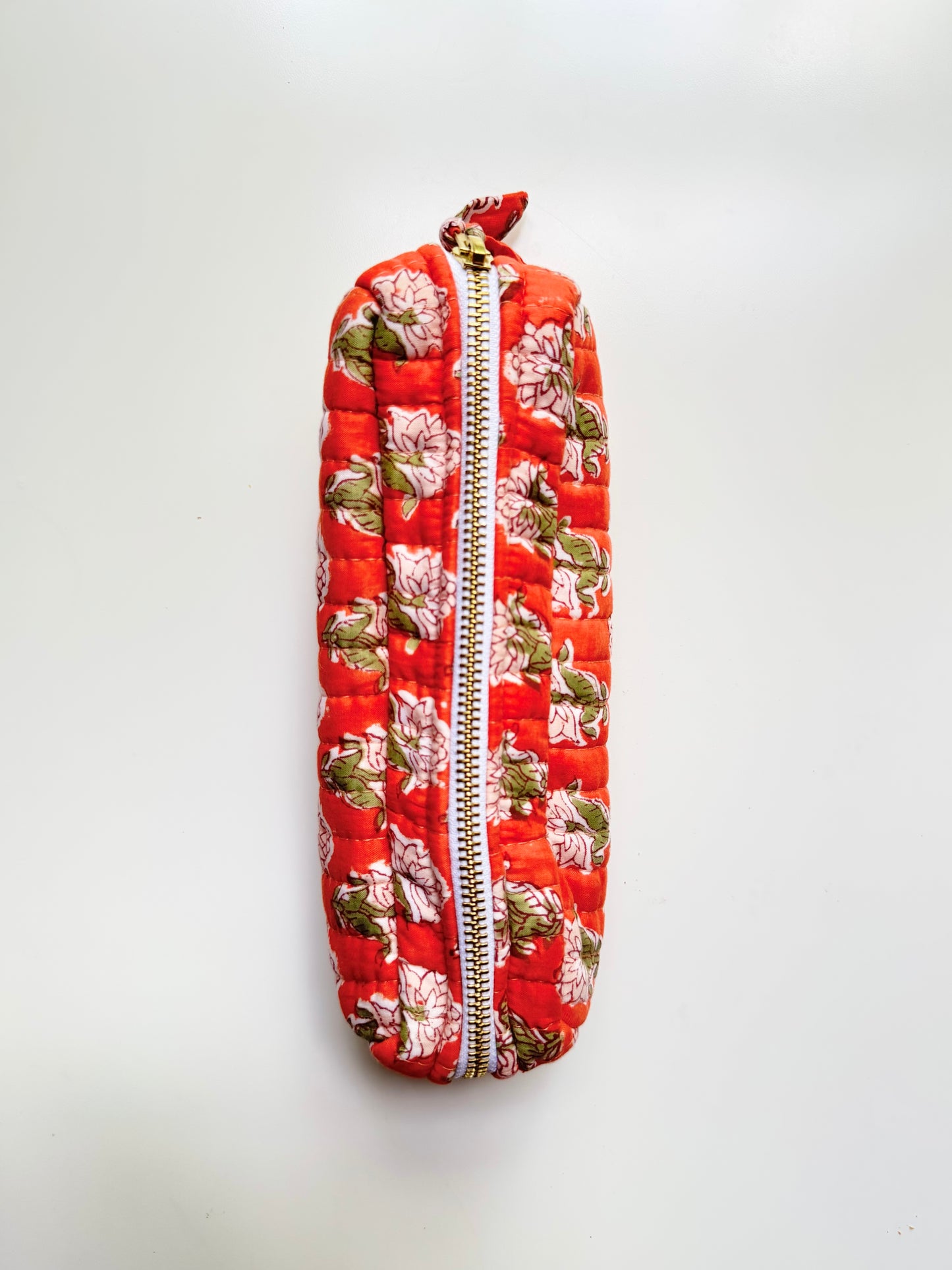 House of Mulmul - Cotton Quilted Makeup Barrel Pouch. A quilted fabric zipper pouch with a vibrant red background and a floral print featuring pink flowers and green leaves, shown against a plain white background.