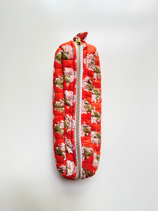 House of Mulmul - Cotton Quilted Makeup Barrel Pouch. A quilted fabric zipper pouch with a vibrant red background and a floral print featuring pink flowers and green leaves, shown against a plain white background.