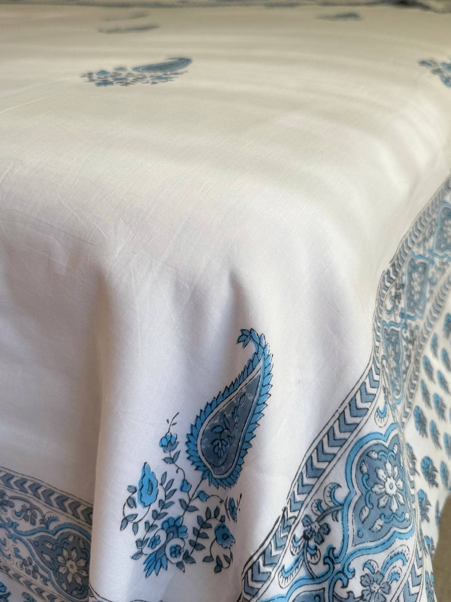 House of Mulmul - Coverlet Dohar blanket. Bedroom with reversible cotton coverlet blanket. Muslin dohar with boota paisley leaf and blue and grey colors, white background.