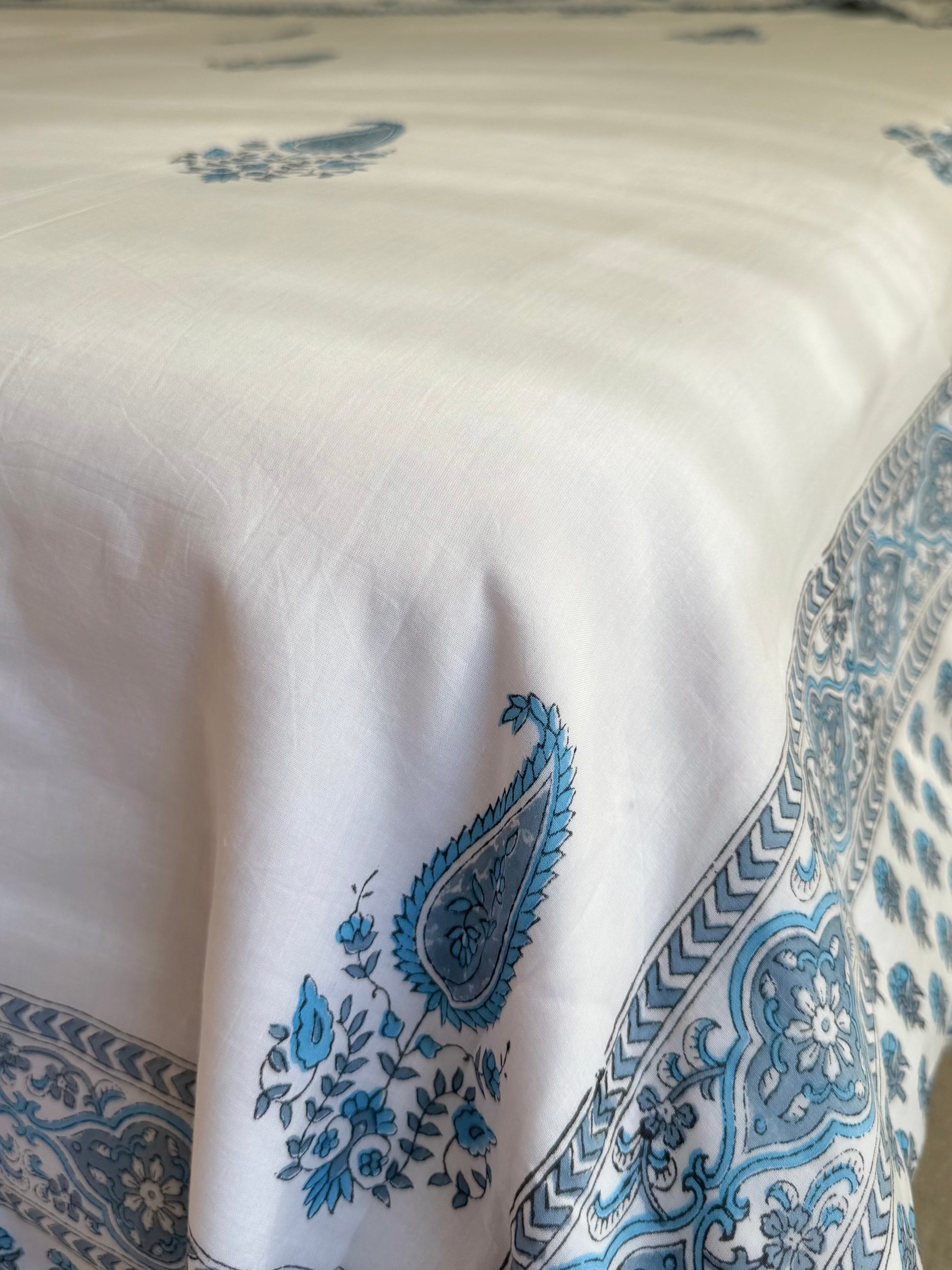 House of Mulmul - Coverlet Dohar blanket. Bedroom with reversible cotton coverlet blanket. Muslin dohar with boota paisley leaf and blue and grey colors, white background.