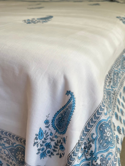 House of Mulmul - Coverlet Dohar blanket. Bedroom with reversible cotton coverlet blanket. Muslin dohar with boota paisley leaf and blue and grey colors, white background.