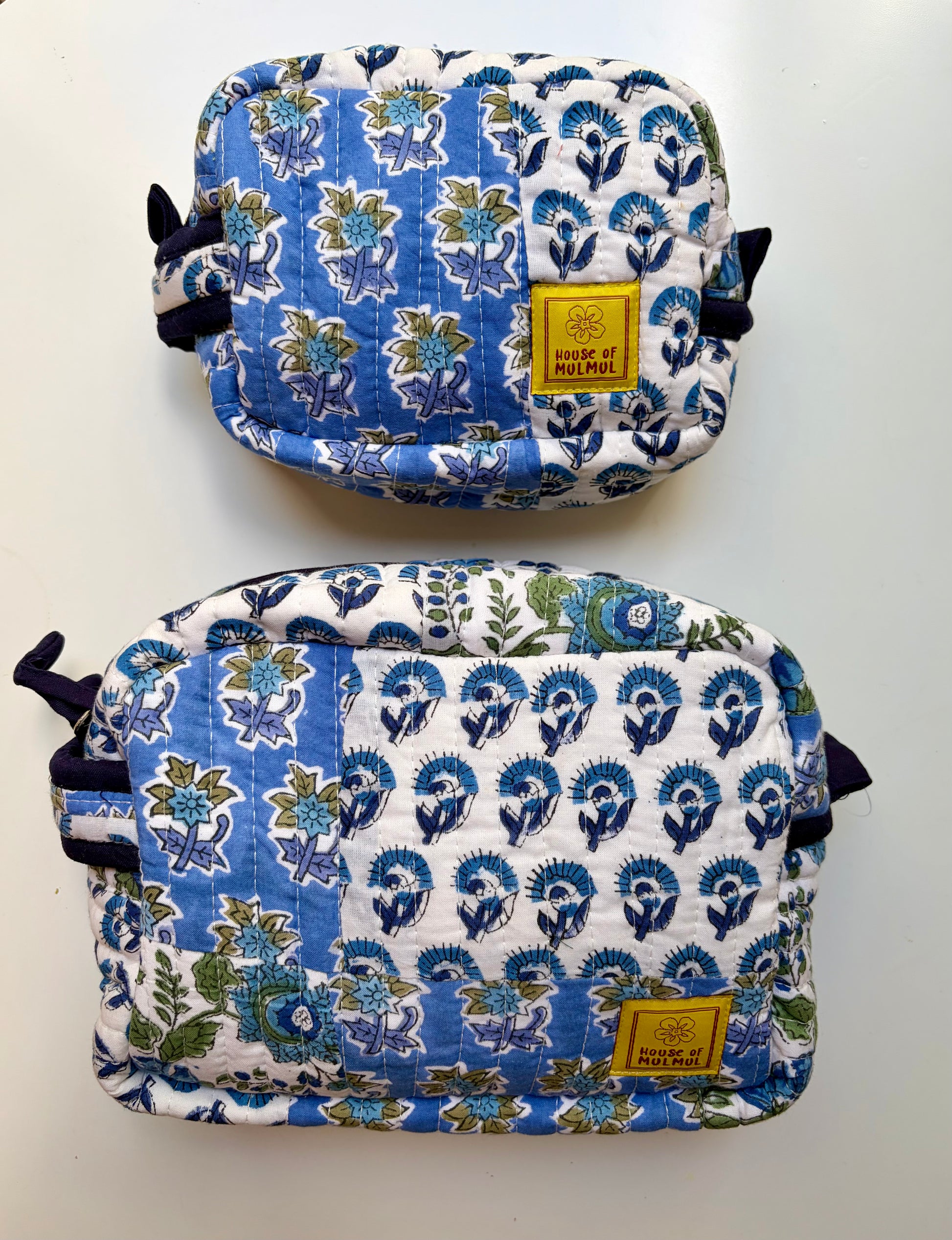 House of Mulmul - Handblock Printed Travel Makeup Quilted Pouch set. Two blue and white patterned bags with a visible brand label on a light gray background