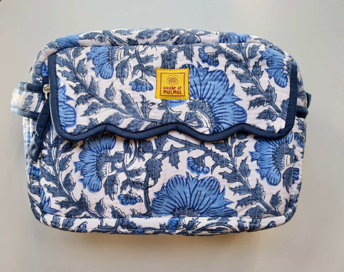 House of Mulmul - Quilted Travel Makeup pouch. Blue floral-patterned bag with a visible brand label on a wooden surface.