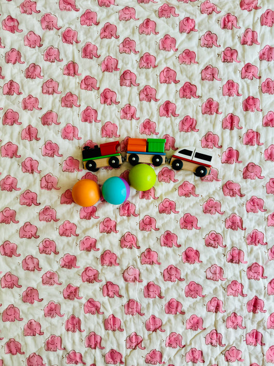 House of Mulmul - Blockprinted Kids Cotton Quilts with reversible design. Colorful toy train with eggs on a quilt background with pink elephant pattern