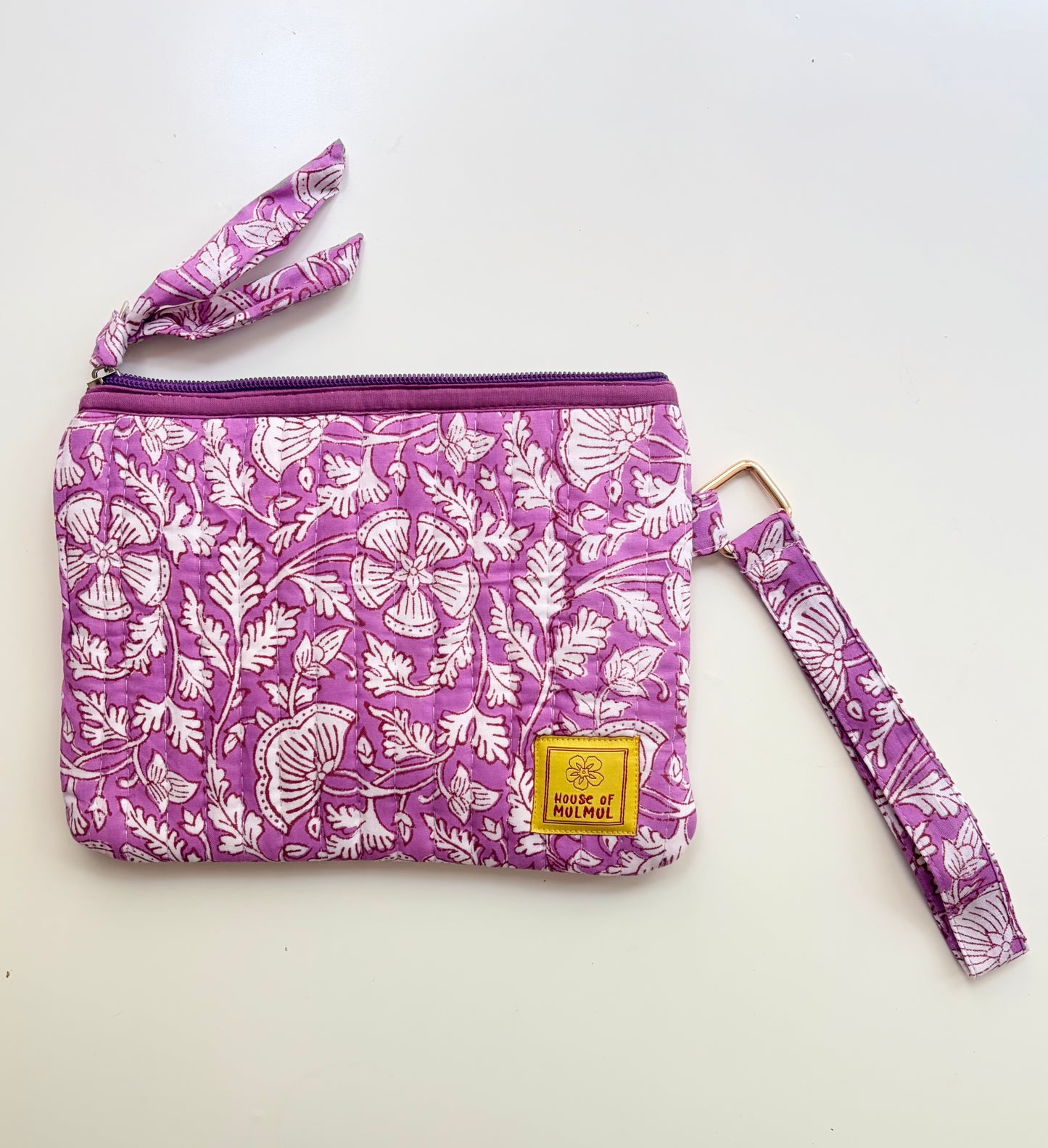 Hand Block Printed Quilted Travel Wristlet Pouch & Organizer. Purple floral-patterned pouch with matching strap on a white background
