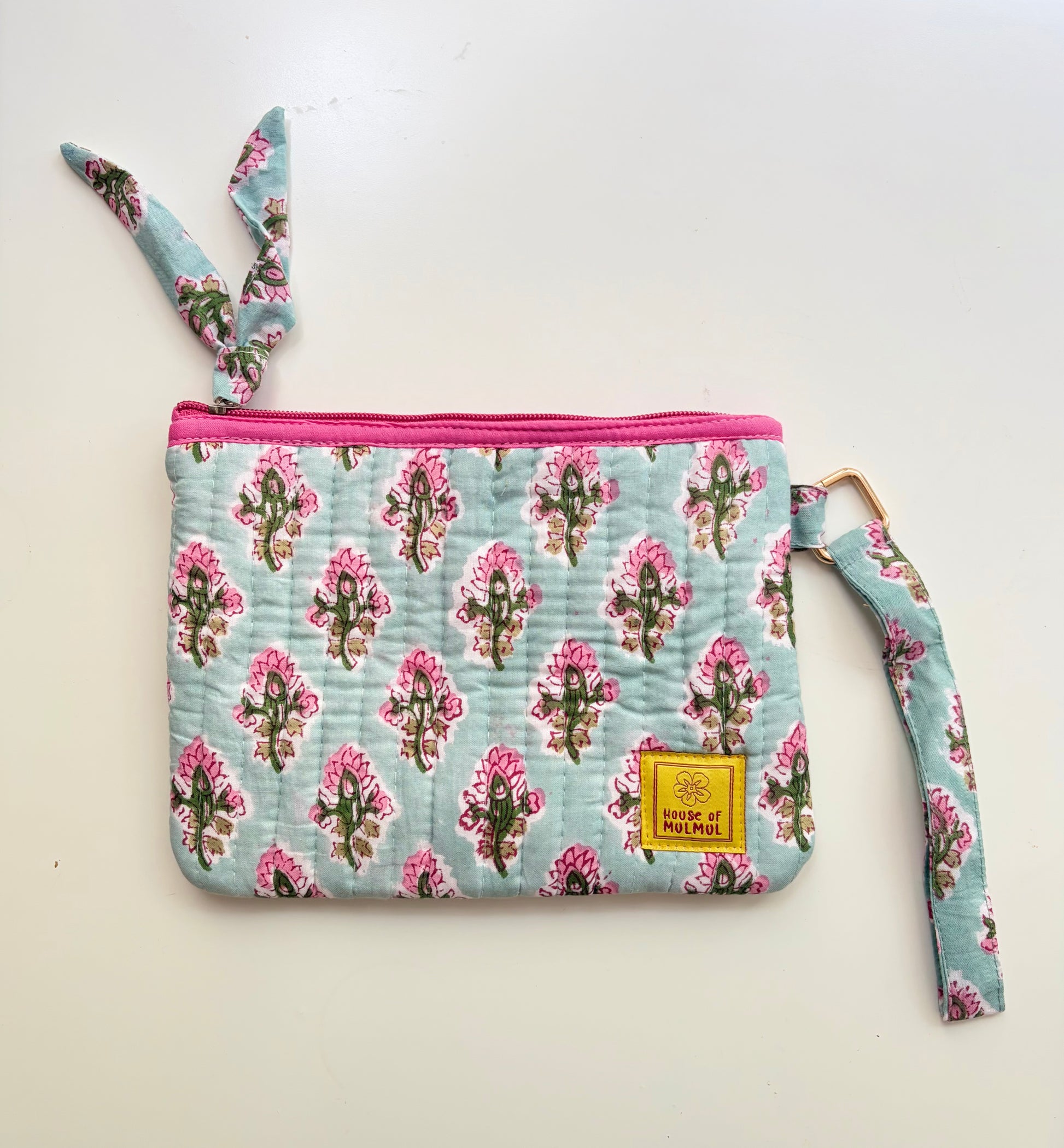 Hand Block Printed Quilted Travel Wristlet Pouch & Organizer. Floral patterned pouch with a strap on a light background