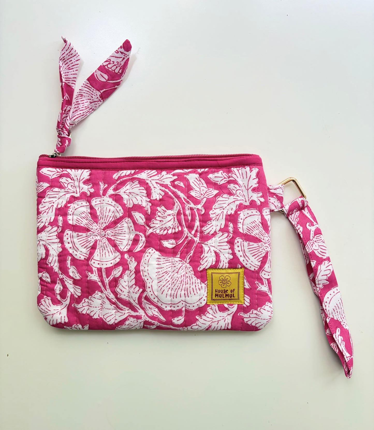 Hand Block Printed Quilted Travel Wristlet Pouch & Organizer. Pink pouch with white floral pattern and matching strap on a white background
