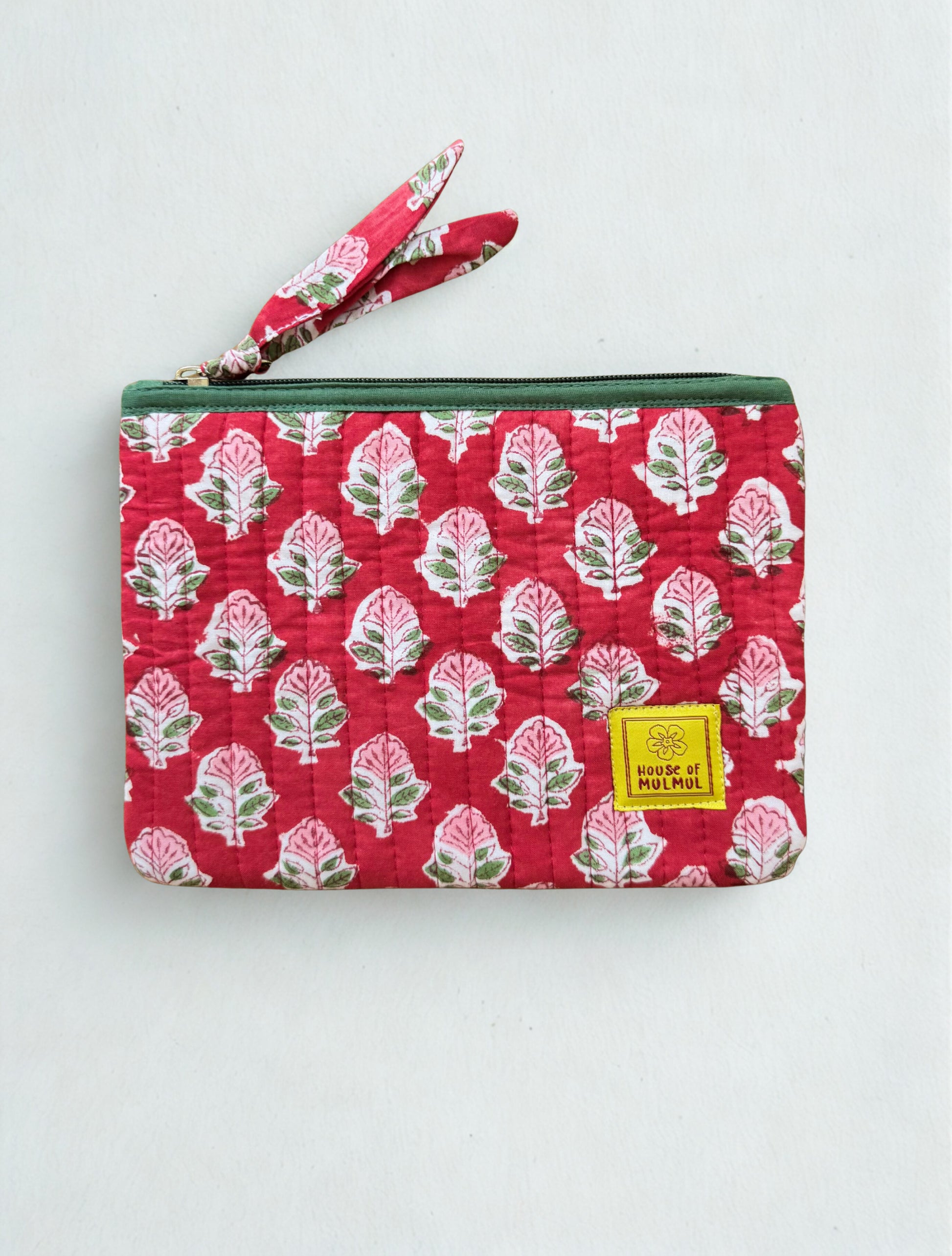 House of Mulmul - Quilted Flat Passport Pouch. Red patterned pouch with a strap on a white background.