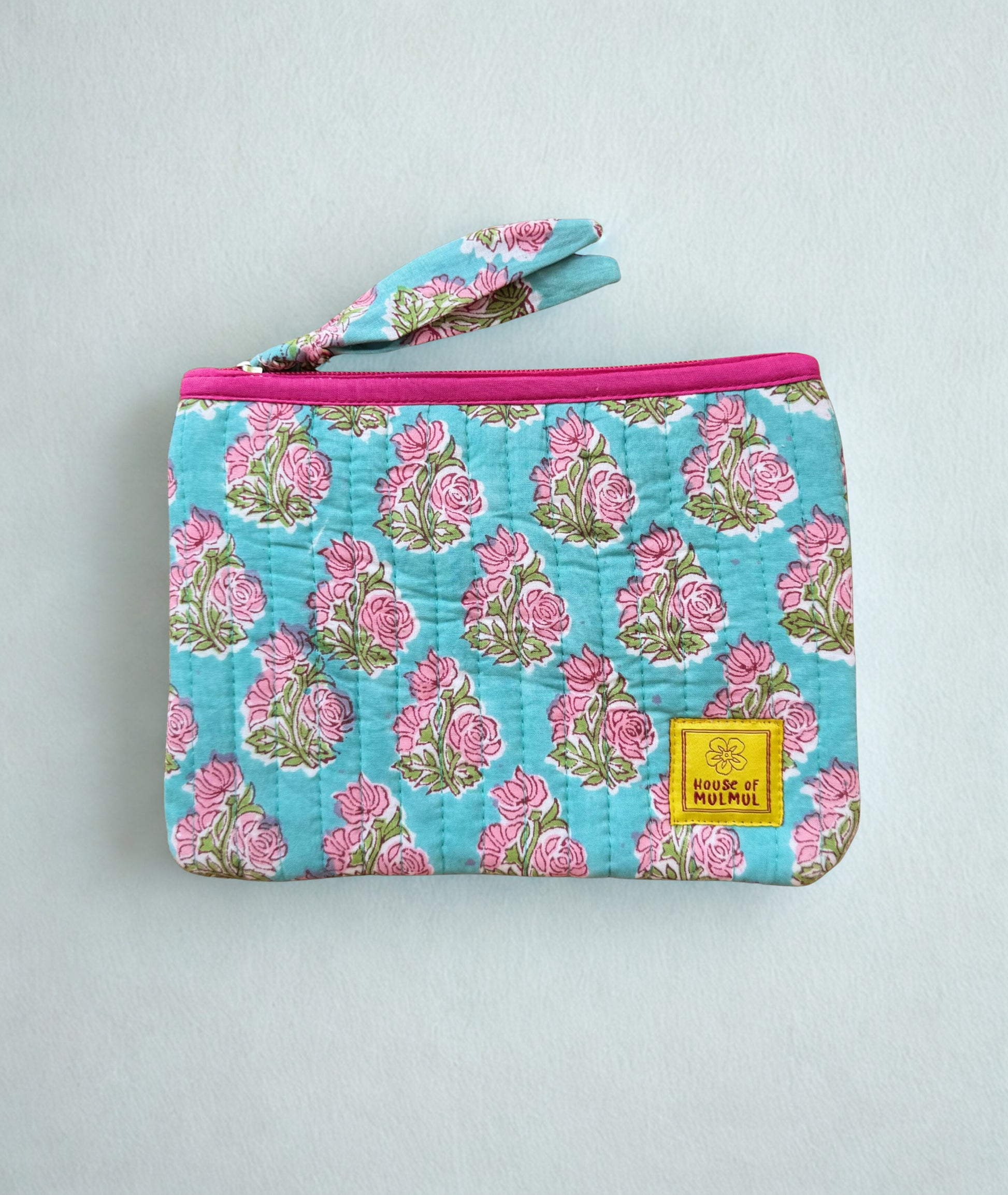 House of Mulmul - Quilted Flat Passport Pouch. Floral-patterned quilted pouch with a pink zipper on a white background.
