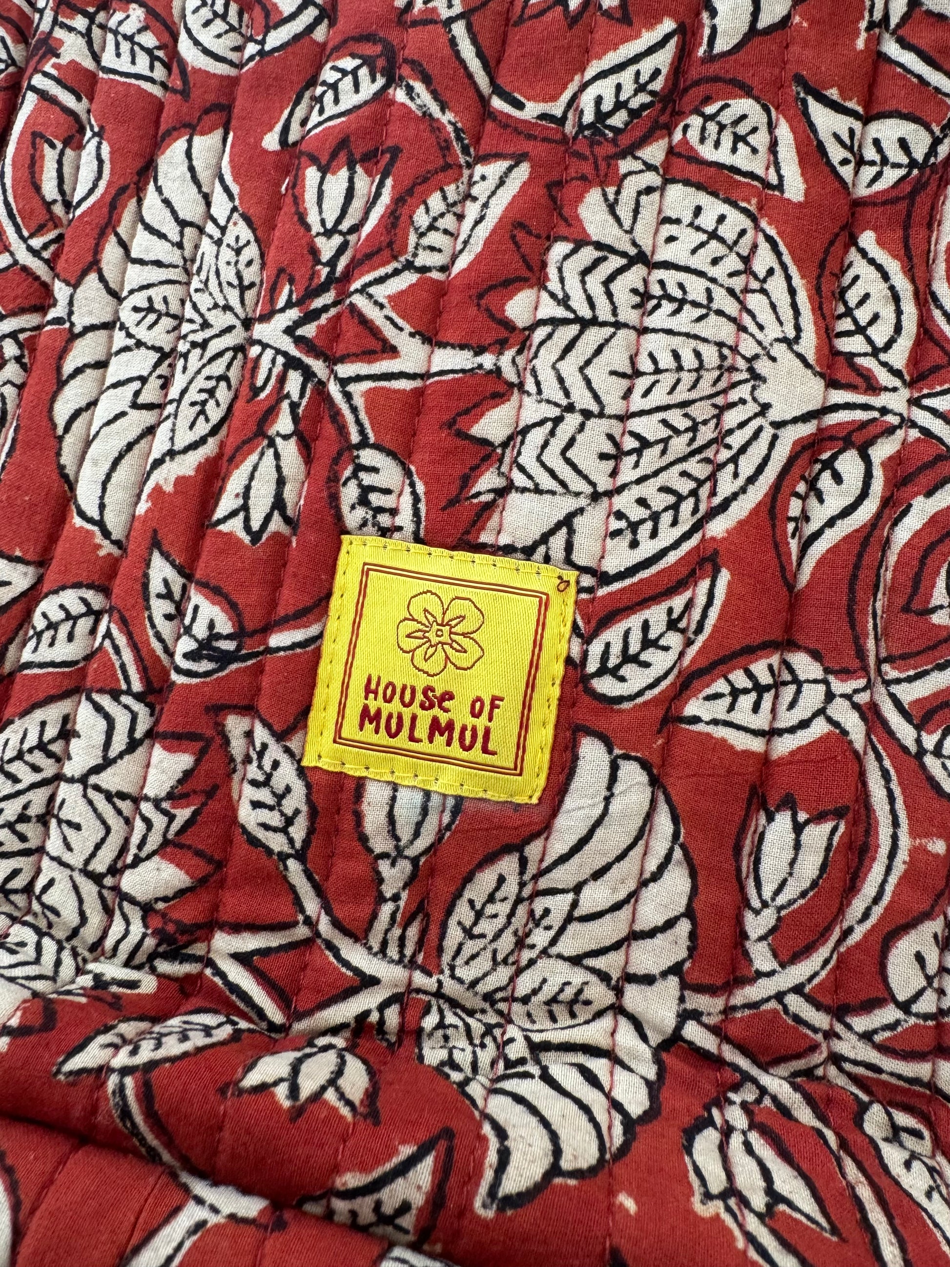 Floral patterned handblock printed fabric with a 'House of Mulmul' label.