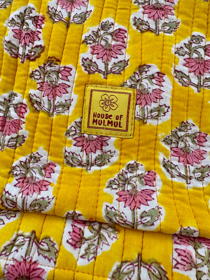 Floral patterned fabric with a 'House of Mulmul' label on a yellow background