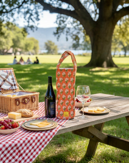 House of Mulmul - Quilted Wine Tote Bag. House of Mulmul - Quilted Wine Tote Bag. Floral wine bottle bag on a picnic table with cheese board and outdoors.