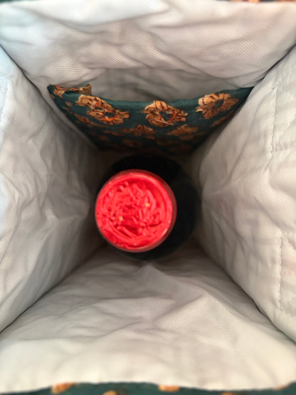 House of Mulmul - Quilted Wine Tote Bags. A close-up view from inside a white quilted insulated bag, looking down at the top of a dark bottle with a bright red cap or label.