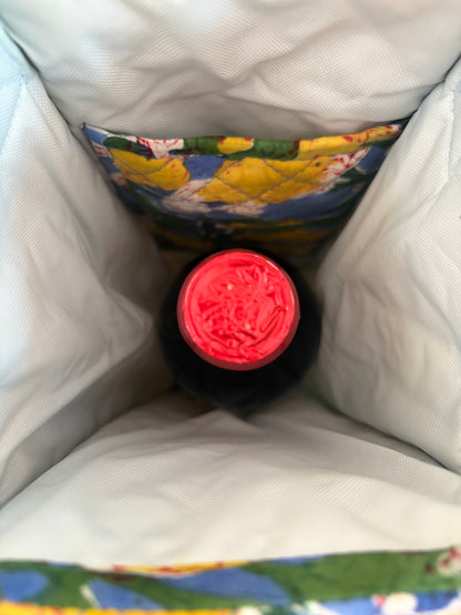 House of Mulmul - Quilted Wine Tote Bags. A close-up view from inside a white insulated bag or cooler pocket, showing the top of a dark bottle with a bright red cap and a colorful floral fabric lining.